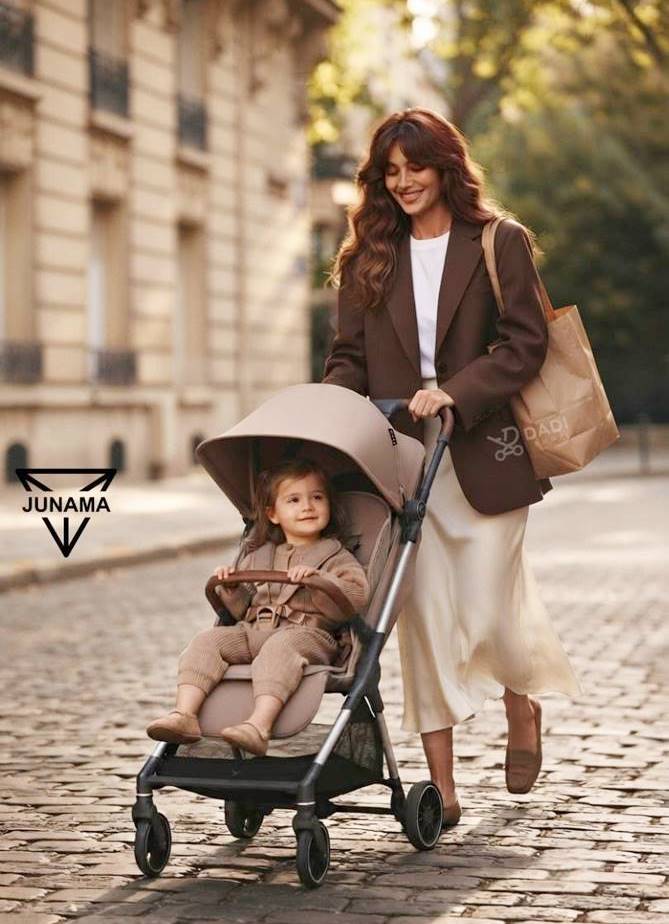 Mama prowadzi lekką spacerówkę z dzieckiem po brukowanej uliczce podczas spaceru.